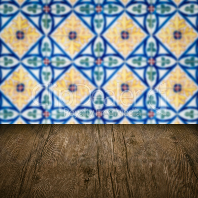 Wood table top and blur vintage ceramic tile pattern wall