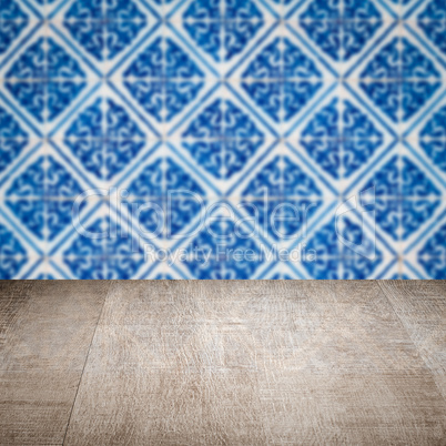 Wood table top and blur vintage ceramic tile pattern wall