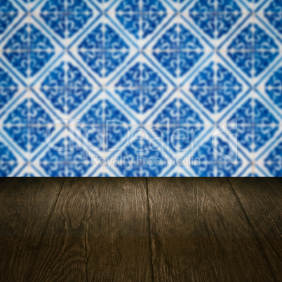 Wood table top and blur vintage ceramic tile pattern wall