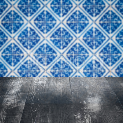 Wood table top and blur vintage ceramic tile pattern wall