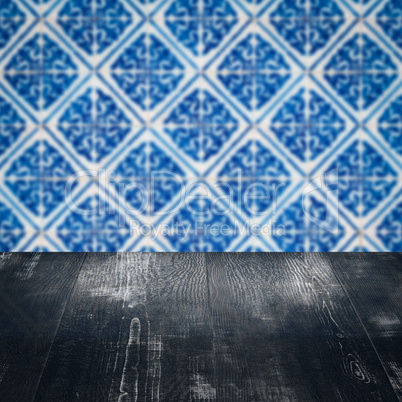 Wood table top and blur vintage ceramic tile pattern wall