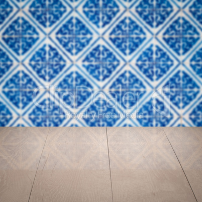 Wood table top and blur vintage ceramic tile pattern wall