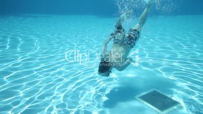 Teenager floats under water in pool