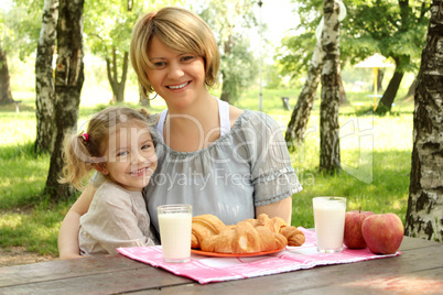 happy mother and daughter with healthy breakfast