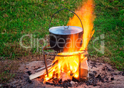 On a fire there is a pan in which the food is cooked.