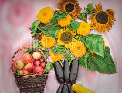 Basket with apples and a bouquet from flowers of a sunflower and