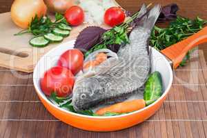 Fish and components for her preparation: vegetables, spices, par