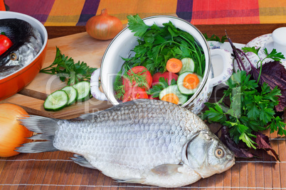 Fish and components for her preparation: vegetables, spices, par