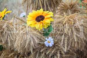 Decoration of artificial flowers and ears of corn.