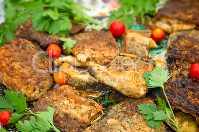 Fried slices of chicken, tomatoes and parsley leaves.