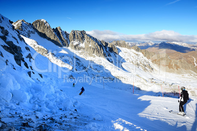 The ski slope and skiers at Presena glacier ski area, Italy.