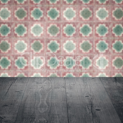 Wood table top and blur vintage ceramic tile pattern wall