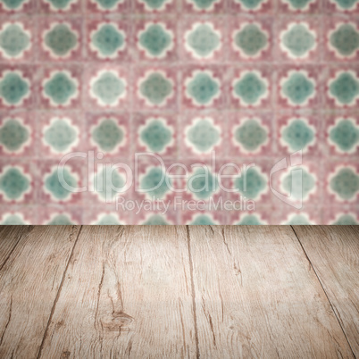 Wood table top and blur vintage ceramic tile pattern wall