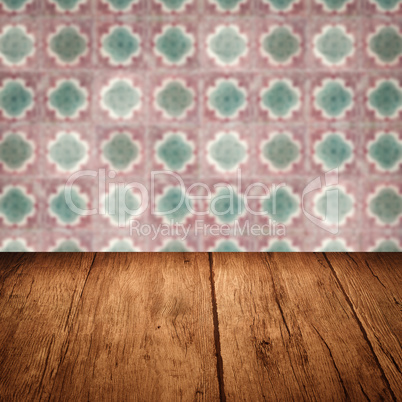 Wood table top and blur vintage ceramic tile pattern wall