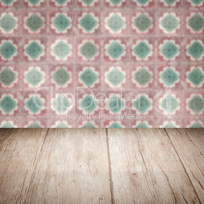 Wood table top and blur vintage ceramic tile pattern wall