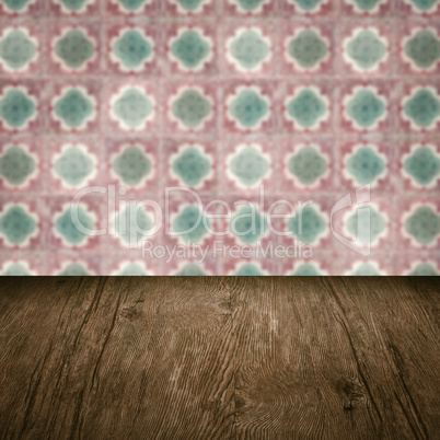 Wood table top and blur vintage ceramic tile pattern wall Wood table top and blur vintage ceramic tile pattern wall