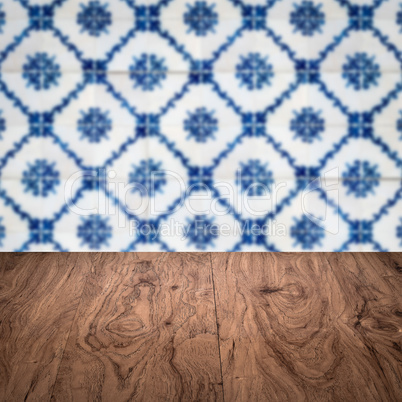 Wood table top and blur vintage ceramic tile pattern wall