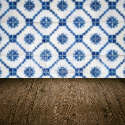 Wood table top and blur vintage ceramic tile pattern wall