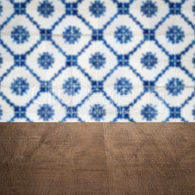 Wood table top and blur vintage ceramic tile pattern wall