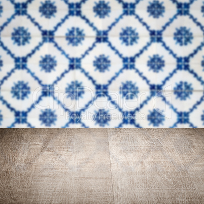 Wood table top and blur vintage ceramic tile pattern wall