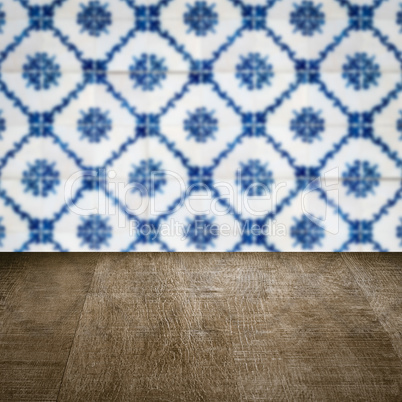 Wood table top and blur vintage ceramic tile pattern wall