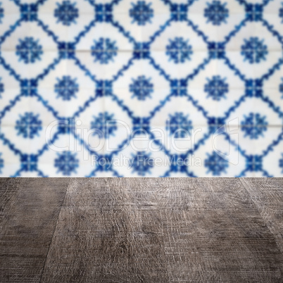 Wood table top and blur vintage ceramic tile pattern wall Wood table top and blur vintage ceramic tile pattern wall