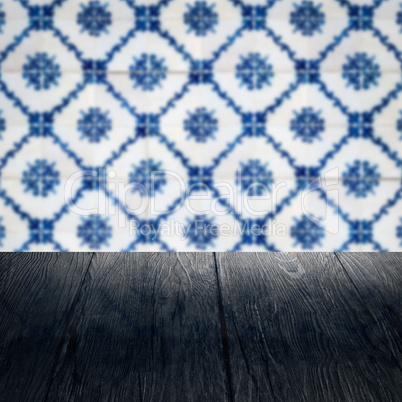 Wood table top and blur vintage ceramic tile pattern wall Wood table top and blur vintage ceramic tile pattern wall