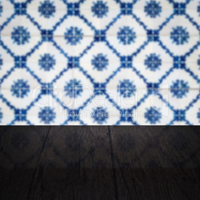 Wood table top and blur vintage ceramic tile pattern wall