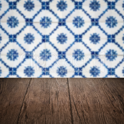 Wood table top and blur vintage ceramic tile pattern wall