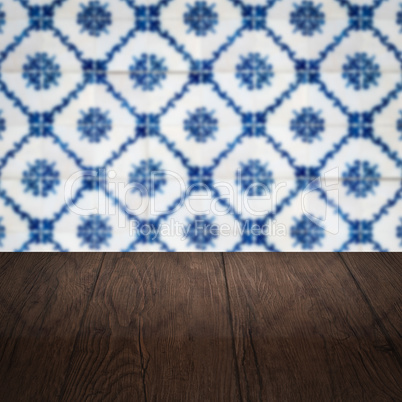 Wood table top and blur vintage ceramic tile pattern wall