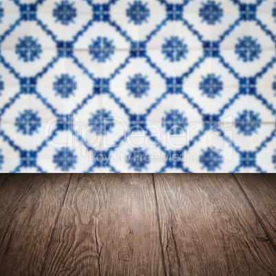 Wood table top and blur vintage ceramic tile pattern wall