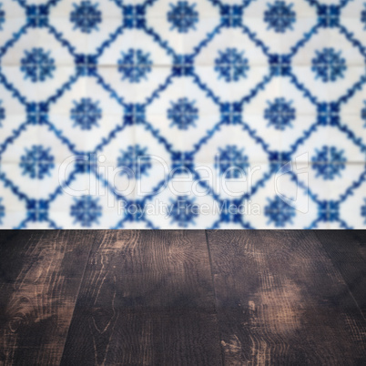 Wood table top and blur vintage ceramic tile pattern wall