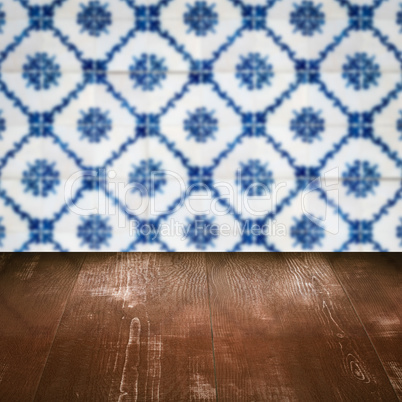 Wood table top and blur vintage ceramic tile pattern wall