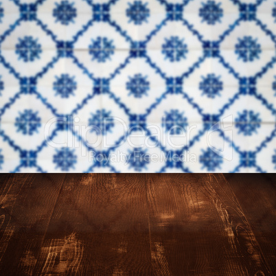 Wood table top and blur vintage ceramic tile pattern wall