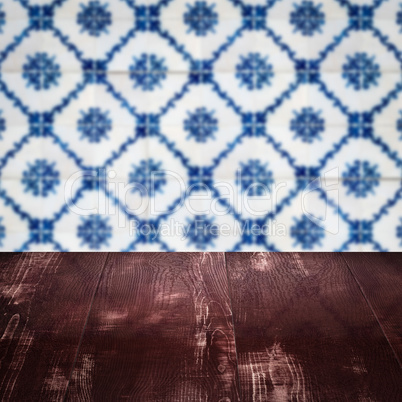 Wood table top and blur vintage ceramic tile pattern wall