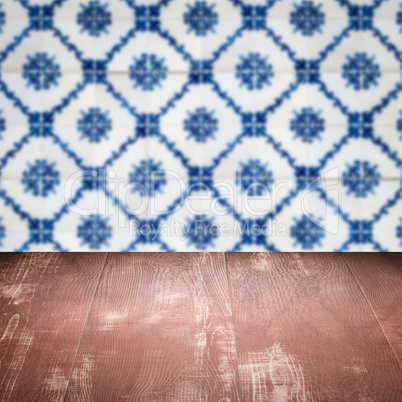 Wood table top and blur vintage ceramic tile pattern wall