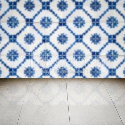 Wood table top and blur vintage ceramic tile pattern wall