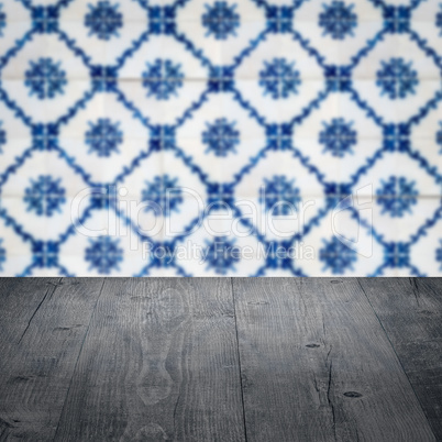 Wood table top and blur vintage ceramic tile pattern wall