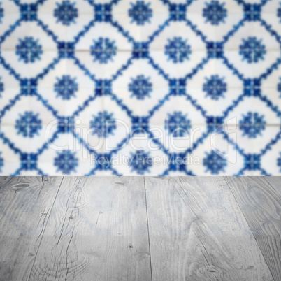 Wood table top and blur vintage ceramic tile pattern wall