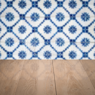 Wood table top and blur vintage ceramic tile pattern wall