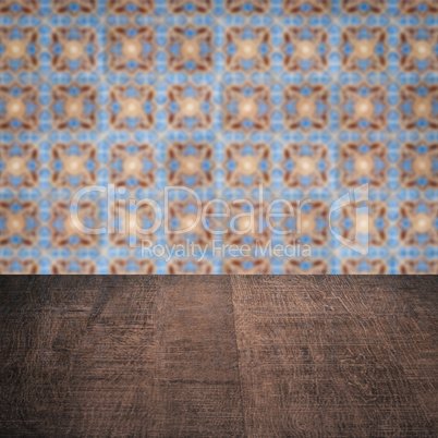 Wood table top and blur vintage ceramic tile pattern wall Wood table top and blur vintage ceramic tile pattern wall