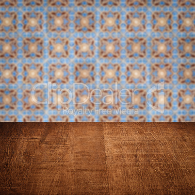 Wood table top and blur vintage ceramic tile pattern wall