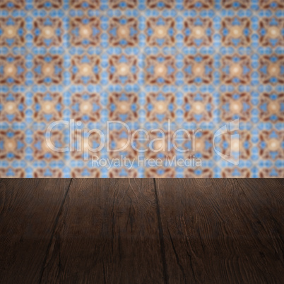 Wood table top and blur vintage ceramic tile pattern wall