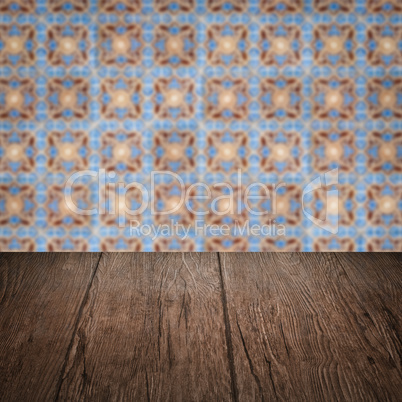 Wood table top and blur vintage ceramic tile pattern wall