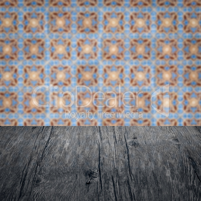 Wood table top and blur vintage ceramic tile pattern wall