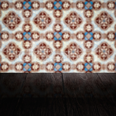 Wood table top and blur vintage ceramic tile pattern wall Wood table top and blur vintage ceramic tile pattern wall