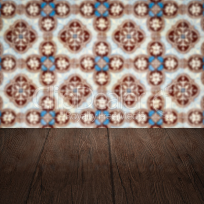 Wood table top and blur vintage ceramic tile pattern wall