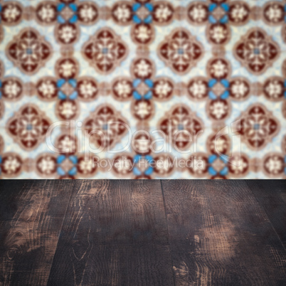 Wood table top and blur vintage ceramic tile pattern wall