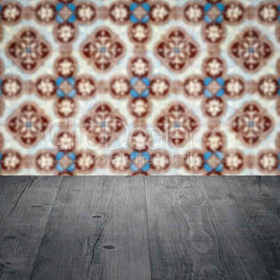 Wood table top and blur vintage ceramic tile pattern wall