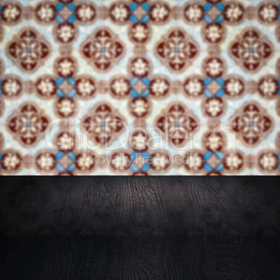 Wood table top and blur vintage ceramic tile pattern wall